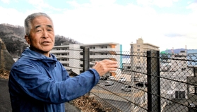 津波の被害にあった釜石市内を見下ろしながら、東日本大震災当時の経験を語る同市元防災課長の佐々木守さん＝岩手県釜石市只越町３