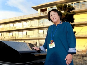 公太さんら生徒１４人の名前が刻まれた慰霊碑をなでる丹野祐子さん＝宮城県名取市閖上西１