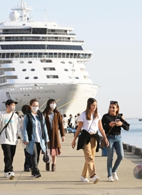 暖かな陽気となった兵庫県内。神戸港には半袖で歩く観光客の姿もあった＝１１日午後、神戸市中央区波止場町