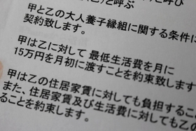 男性が養親と交わした契約書