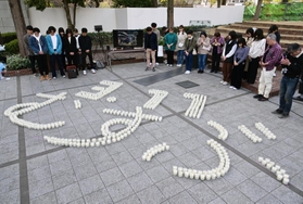 「３・１１　むすぶ」の文字にかたどられたろうそくを囲み、黙とうする参列者＝１１日午後２時４６分、神戸市中央区加納町６