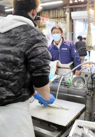 コロナ借金を抱え、鮮魚店で働く男性（手前）と、様子を見守る社会福祉協議会の元佐朋亨さん＝相生市内