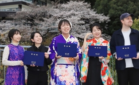 通称名で書かれた学位記を手に、同じ研究室の卒業生らと喜び合う久保明日香さん（中央）＝２４日午後、神戸市灘区鶴甲１、神戸大学（撮影・吉田敦史）