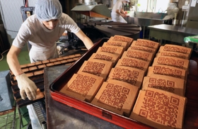 ＱＲコードが焼き付けられた瓦せんべい。伝統の味に載る現代模様の意外性が好評という＝神戸市中央区元町通６、亀井堂総本店