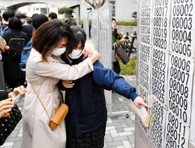 自身の番号を見つけ、喜び合う生徒ら＝１７日午前、神戸市長田区池田谷町２、長田高校