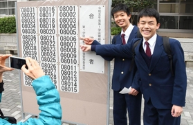 自身の番号を見つけ、喜び合う生徒ら＝１７日午前、神戸市長田区池田谷町２、長田高校
