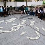 「３・１１　むすぶ」の文字にかたどられたろうそくを囲み、黙とうする参列者＝１１日午後２時４６分、神戸市中央区加納町６