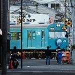 ＪＲ和田岬駅に到着する１０３系。商店街のすぐそばを通るその姿を住民らがカメラに収めていた＝神戸市兵庫区小松通２