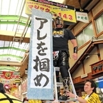 阪神タイガースの優勝を祈って、マジック「１４３」を取り付けた、尼崎中央３丁目商店街の名誉応援団長プロレスラー空牙（くうが）さん＝２９日午前、尼崎市神田中通３