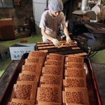 ＱＲコードが焼き付けられた瓦せんべい。伝統の味に載る現代模様の意外性が好評という＝神戸市中央区元町通６、亀井堂総本店