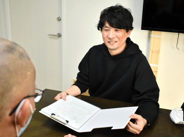 利用者と話す田村匠さん＝大阪市生野区