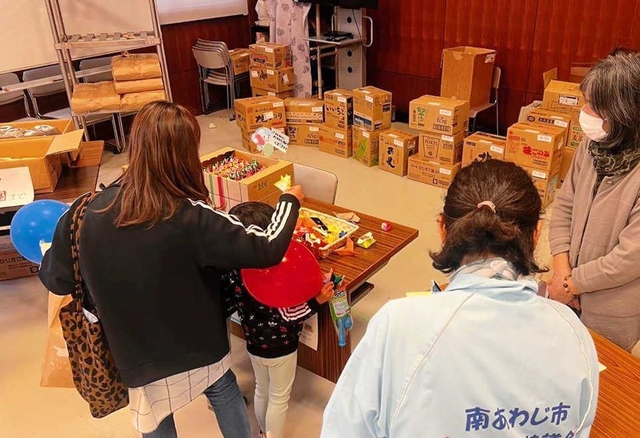 無料配布会で食料を受け取る親子ら＝南あわじ市広田広田（提供）