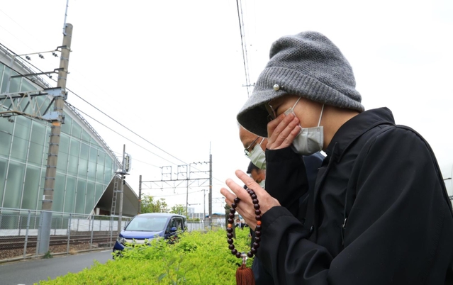 事故発生時刻に合わせ、現場近くで黙とうする女性ら＝２５日午前９時１８分、尼崎市久々知３（撮影・鈴木雅之）