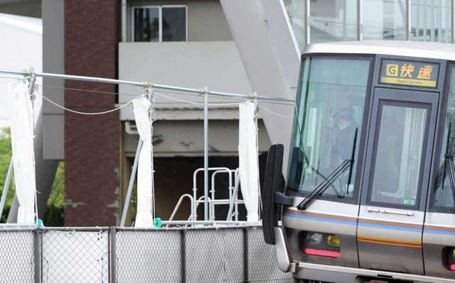 事故現場前を通過する電車内で、車掌が頭を下げた＝２５日午前７時３７分、尼崎市久々知３（撮影・鈴木雅之）