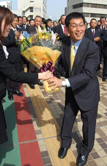 明石市役所に初登庁し、庁舎前で花束を受け取る泉房穂市長＝２０１１年５月２日