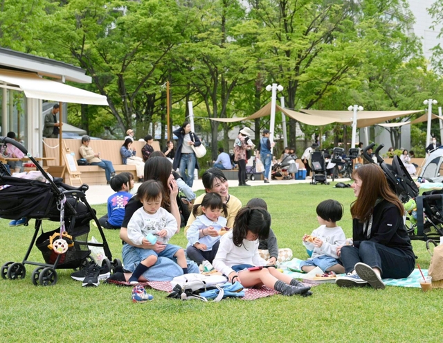 芝生の上くつろぐ親子ら＝２９日午後、神戸市中央区加納町６、東遊園地