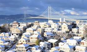 明石海峡大橋を望む住宅街。寒波到来の日。降雪で屋根が白く染まった＝２０２３年１月、神戸市垂水区高丸５