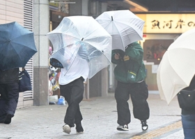 強風にあおられ、傘を傾けながら歩く人ら＝７日午前、神戸市垂水区日向１（撮影・中西幸大）