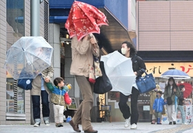 強風にあおられ、傘を傾けながら歩く人ら＝７日午前１０時５３分、神戸市垂水区日向１（撮影・中西幸大）