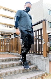 「シーブレース」を右脚に装着して階段を歩く男性＝神戸市西区曙町、兵庫県立総合リハビリテーションセンター