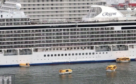 客船「セブンシーズ・エクスプローラー」の横で浮かぶ黄色いレスキューボート＝１４日午前、神戸市中央区（撮影・長嶺麻子）