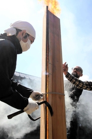 焼き板づくりでは、３枚の杉板を組んで煙突状に直立させ、中から火であぶると内側が炭化する＝豊岡市竹野町