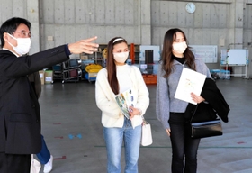 兵庫県広域防災センターの担当者から説明を聞く森田莉碧さん（右）と千々岩瑠菜さん（中央）＝三木市志染町御坂