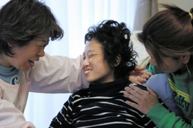 ２００６年３月、母親のもも子さん（左）、姉の敦子さんに囲まれ、笑顔を見せる順子さん＝兵庫県西宮市