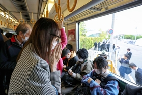 尼崎ＪＲ脱線事故から18年となり、現場を通過する電車内で手を合わせる女性＝25日午前９時16分、兵庫県尼崎市（代表撮影）