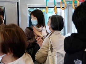 尼崎ＪＲ脱線事故から18年となり、現場近くを通過する電車内で手を合わせる乗客＝25日午前９時16分、兵庫県尼崎市（代表撮影）