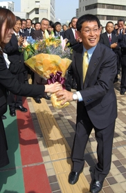 明石市役所に初登庁し、庁舎前で花束を受け取る泉房穂市長＝２０１１年５月２日