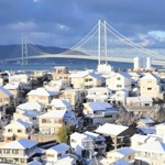 明石海峡大橋を望む住宅街。寒波到来の日。降雪で屋根が白く染まった＝２０２３年１月、神戸市垂水区高丸５