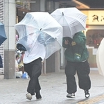 強風にあおられ、傘を傾けながら歩く人ら＝７日午前、神戸市垂水区日向１（撮影・中西幸大）