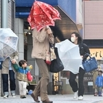 強風にあおられ、傘を傾けながら歩く人ら＝７日午前１０時５３分、神戸市垂水区日向１（撮影・中西幸大）