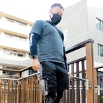 「シーブレース」を右脚に装着して階段を歩く男性＝神戸市西区曙町、兵庫県立総合リハビリテーションセンター