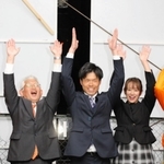 当選を確実にし、万歳する橋本慧悟氏（中央）と泉房穂市長（左）ら＝明石市大明石町２