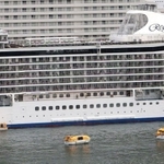 客船「セブンシーズ・エクスプローラー」の横で浮かぶ黄色いレスキューボート＝１４日午前、神戸市中央区（撮影・長嶺麻子）