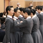 在校生から校章バッジの贈呈を受ける新入生ら＝宝塚音楽学校（同校提供）