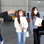 兵庫県広域防災センターの担当者から説明を聞く森田莉碧さん（右）と千々岩瑠菜さん（中央）＝三木市志染町御坂