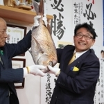 支援者から贈られたタイを手に当選を喜ぶ清元秀泰氏（右）＝姫路市安田２（撮影・辰巳直之）