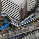マンションに巻き付くように、「くの字」型に大破したＪＲ宝塚線の快速電車の２両目。１両目はマンションの立体駐車場に潜り込んで見えない＝２００５年４月２５日、尼崎市久々知
