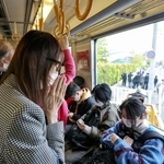 尼崎ＪＲ脱線事故から18年となり、現場を通過する電車内で手を合わせる女性＝25日午前９時16分、兵庫県尼崎市（代表撮影）
