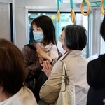 尼崎ＪＲ脱線事故から18年となり、現場近くを通過する電車内で手を合わせる乗客＝25日午前９時16分、兵庫県尼崎市（代表撮影）