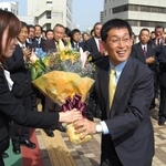 明石市役所に初登庁し、庁舎前で花束を受け取る泉房穂市長＝２０１１年５月２日