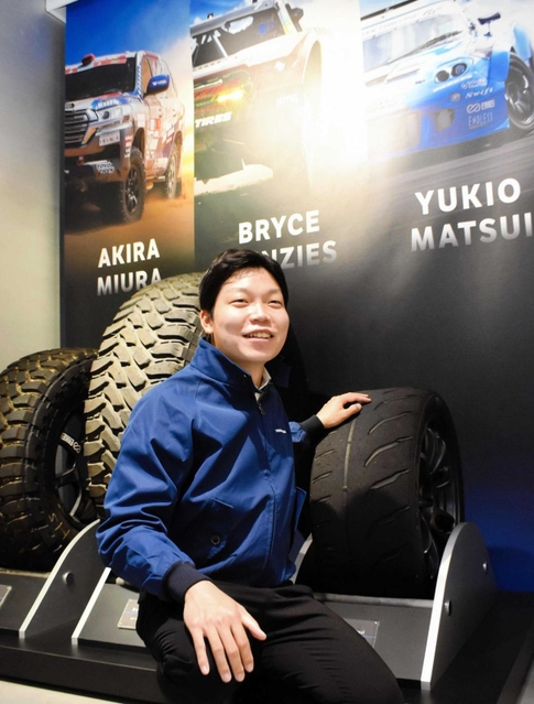 国際レースやラリーなどで使用されたタイヤに触れる宮園拓真さん＝伊丹市藤ノ木２、トーヨータイヤ本社