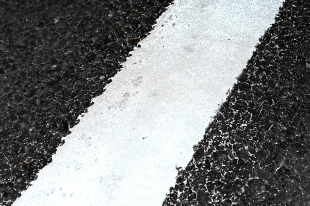 引き直したばかりの白線。塗料に混ざったガラスビーズが光を反射するため、夜間でも見やすい＝西宮市樋ノ口町２