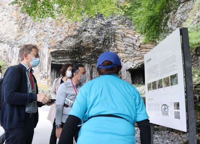 ２０２２年１０月の現地審査で、山陰海岸ジオパークの玄武洞公園を視察するユネスコの審査員ら＝豊岡市赤石