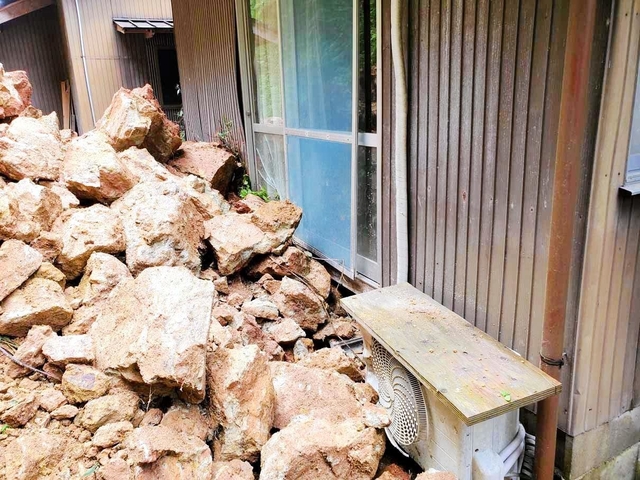 山腹が崩れ、民家に押し寄せた岩石＝８日、豊岡市出石町片間（豊岡市提供）