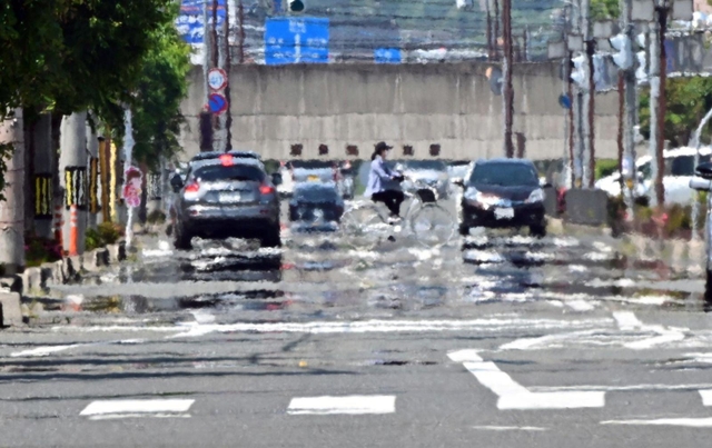道路が熱せられて水たまりができたような「逃げ水」の現象が見られた＝１７日午後、豊岡市加広町（撮影・斎藤雅志）