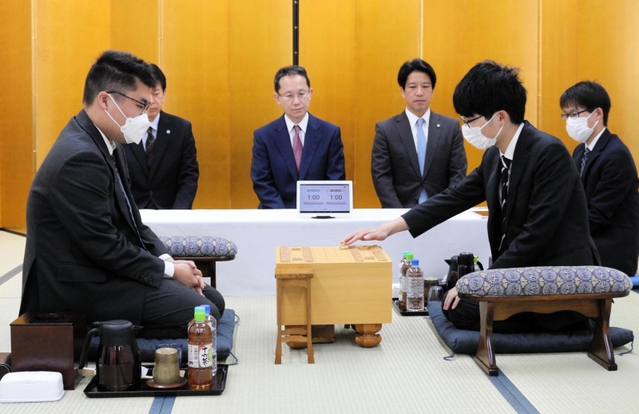 加古川青流戦の開幕局で初手を指す藤本渚四段（右）。左は高田明浩四段＝２７日午前、加古川市加古川町溝之口